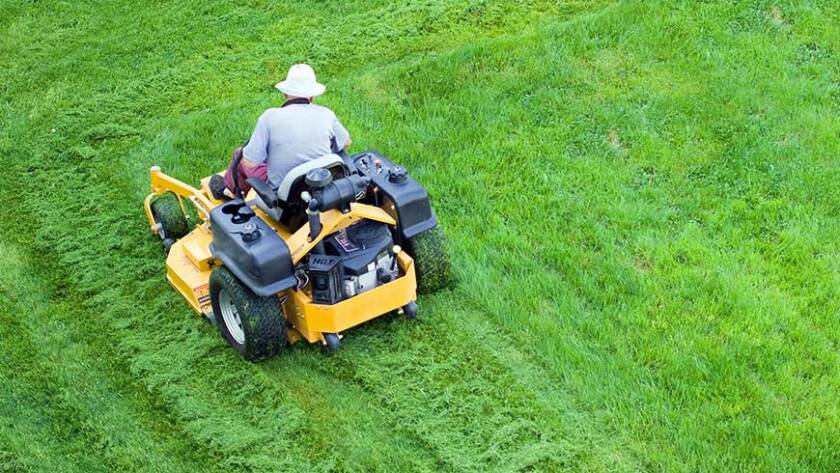 Male gardener working with lawn mower